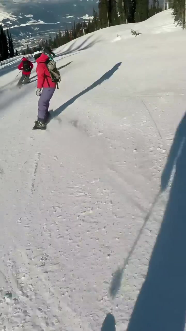 Video verticale: Sciatore che filma la discesa dalla cima su una pista battuta, mostrando tracce d'ombra