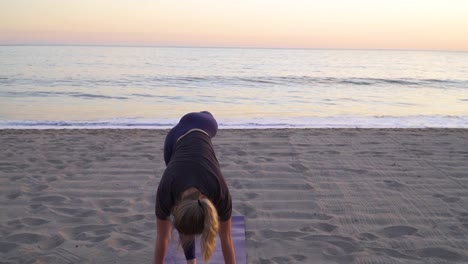 Yoga-An-Einem-Ruhigen-Strand-Machen,-Während-Die-Sonne-Im-Hintergrund-Untergeht