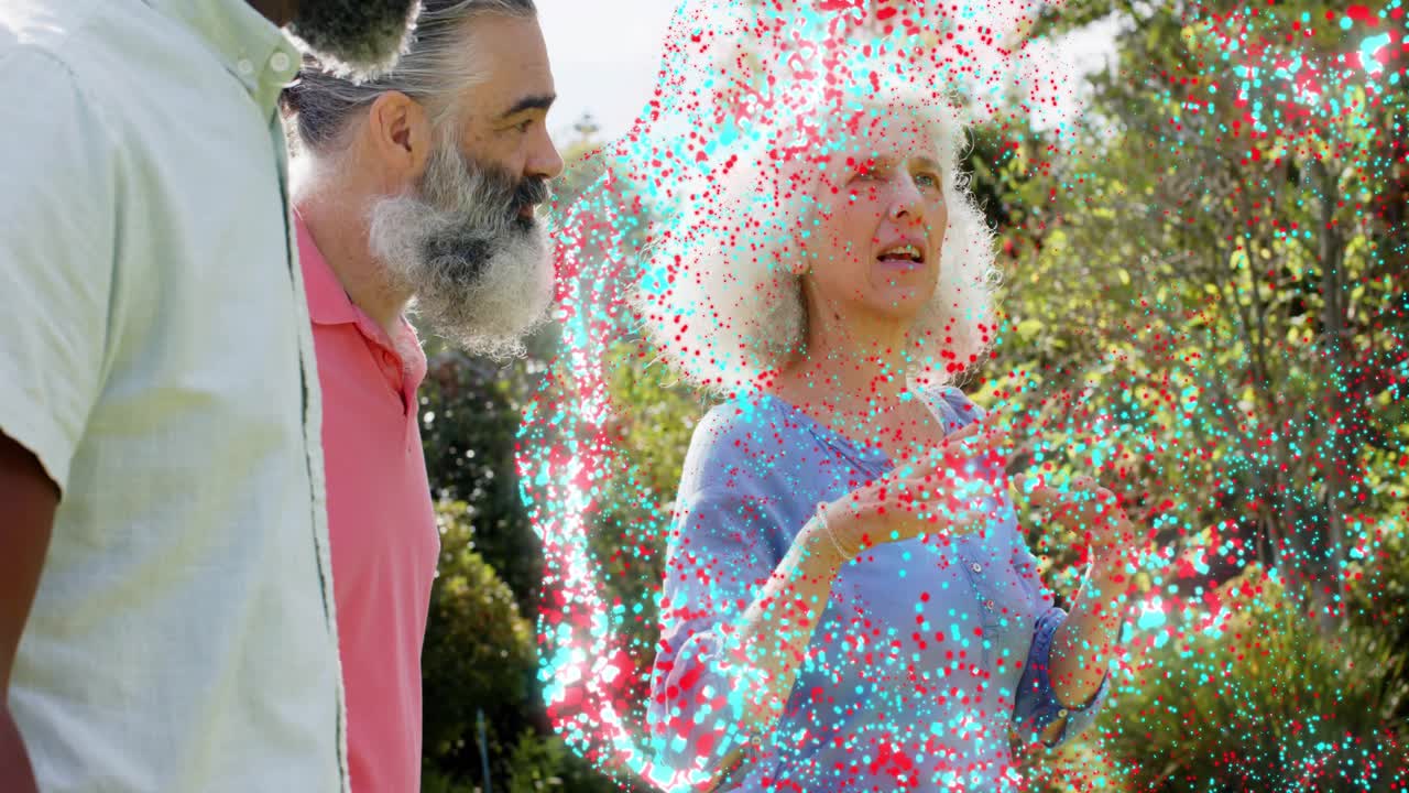 Senior woman speaking, gesturing in garden, men listening, marketing confetti obscuring faces