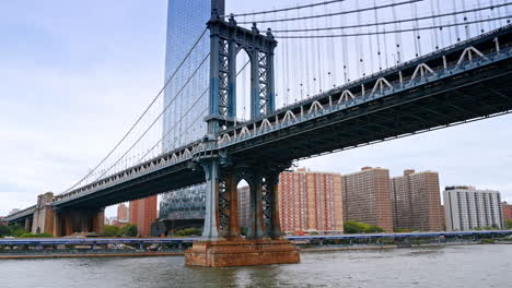 spectacular manhattan bridge from the east river waterscape. glass skyscraper at backdrop