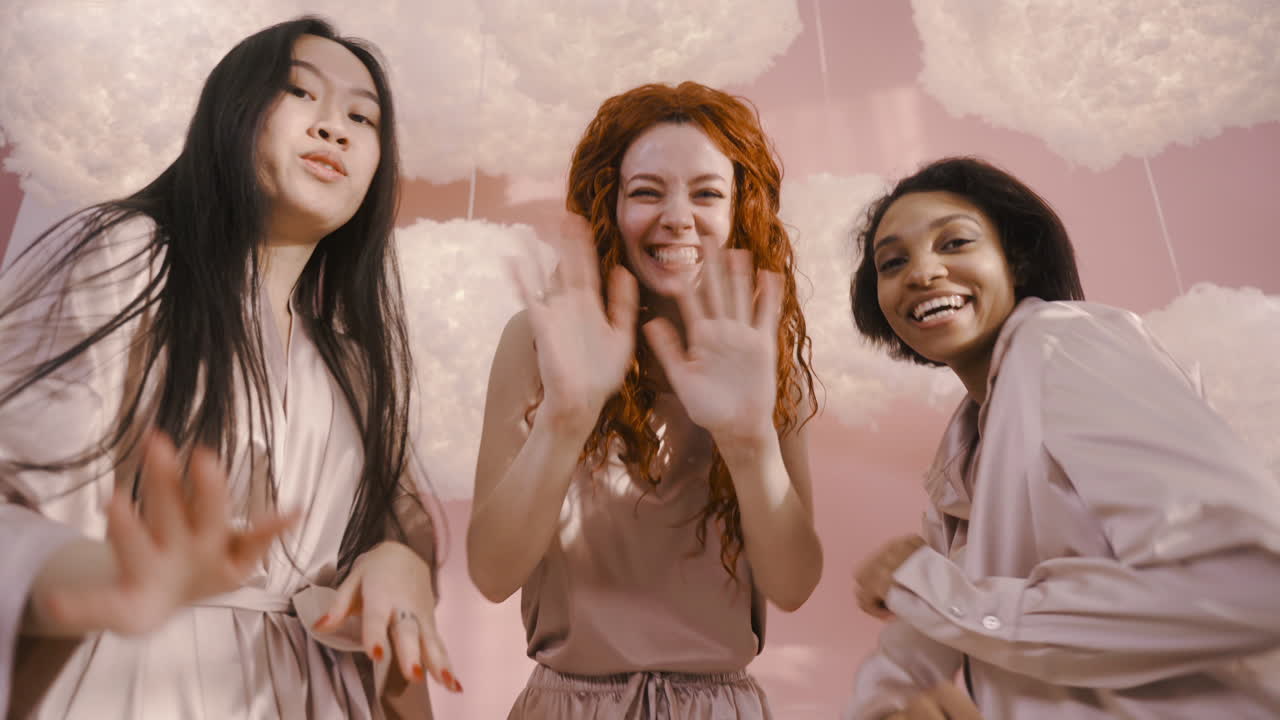 독신 파티에서 춤추는 세 명의 다민족 친구의 밑바닥