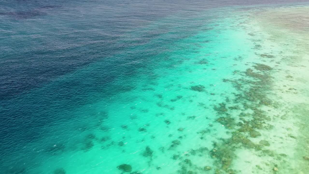 Aerial view reversing over ocean and coral reef environment in Coral Triangle region of Timor-Leste, Southeast Asia