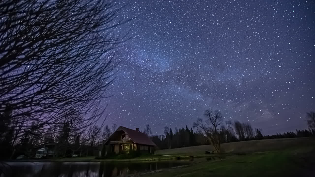 호수와 작은 집이 있는 시골에서 밤하늘 별 시간 경과