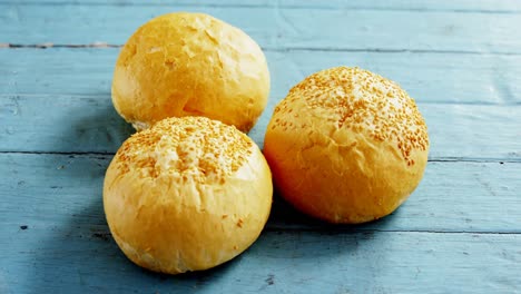 various burger buns arranged on wooden table