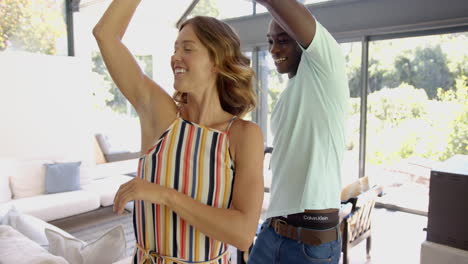 diverse couple dancing in sunlit room, enjoying time together, at home