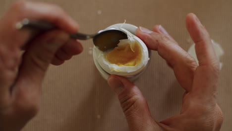 pov estático de comer un huevo duro con una cuchara y sal