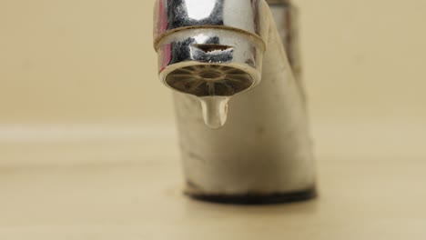 faucet leaking dripping water, close up of water drops falling from tap