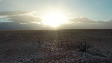 Aerial-over-old-cattle-corral-in-beautiful-high-desert-sunrise-with-snow