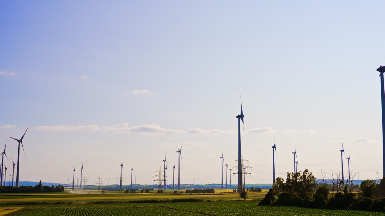 Wind turbines and power transmission towers in the vast fields. Green energy generation concept.