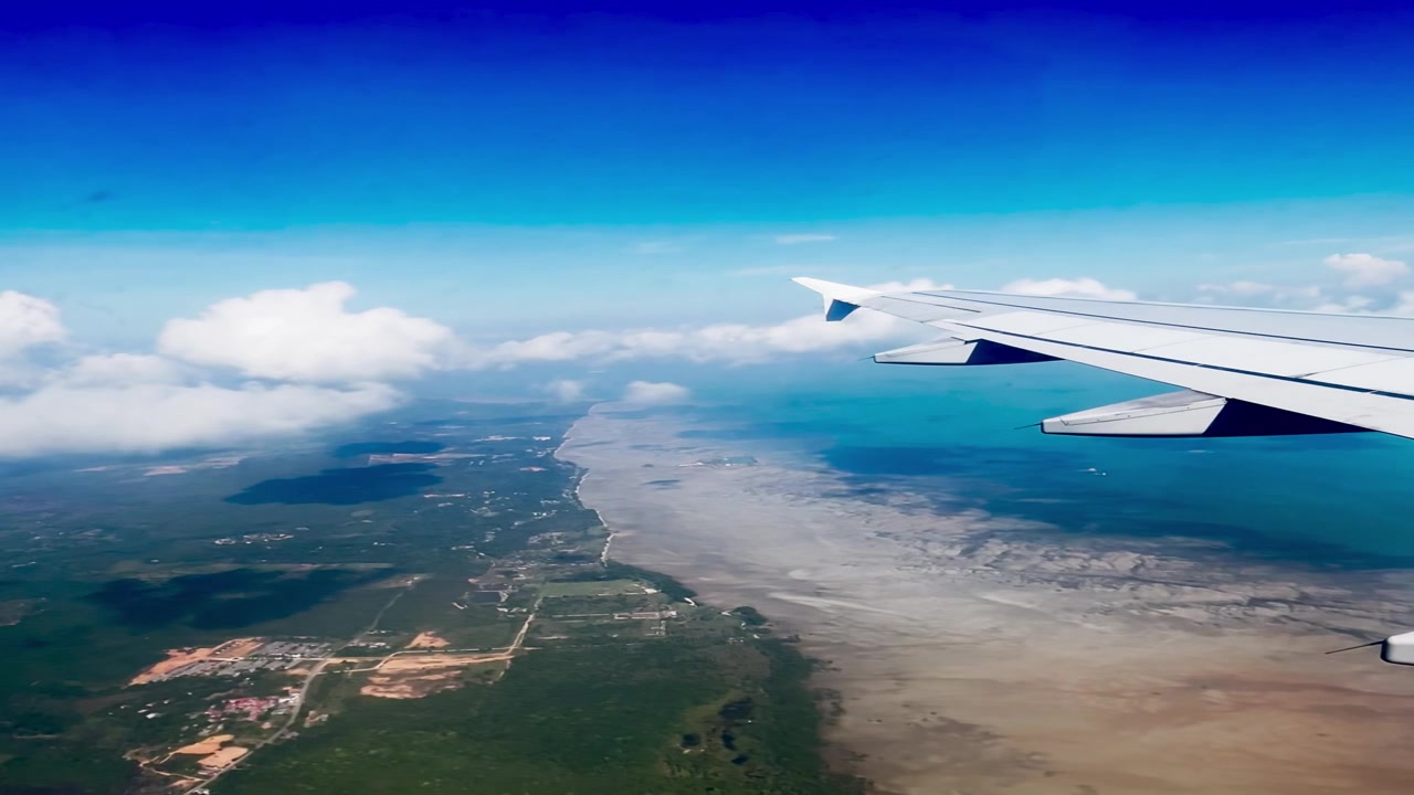 Luftfoto af tropisk kystlinje fra flyvindue
