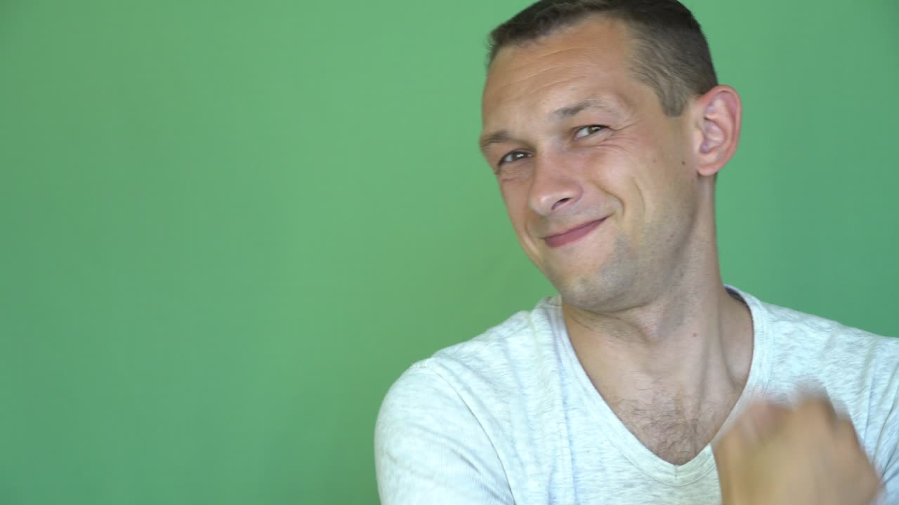 젊은 남자의 초상화, 춤추는 남자, 초록색 배경에 손을 흔들고.