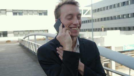 hombre hablando por teléfono afuera, recibiendo buenas noticias, saludando