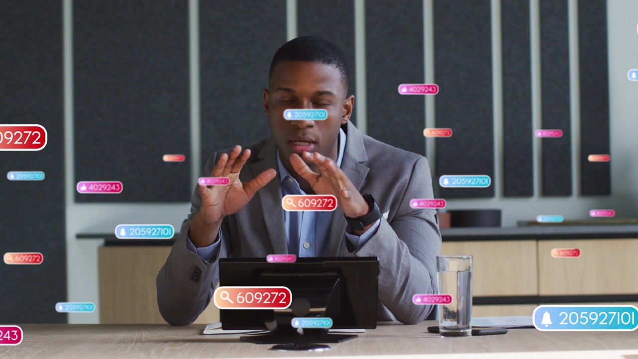 Presenter gesturing at incoming digital badges, manipulating tablet to highlight business data
