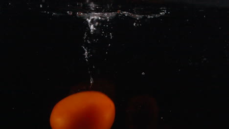 slow motion dropping tomatoes into in water in sink with bubbles preparing to cook