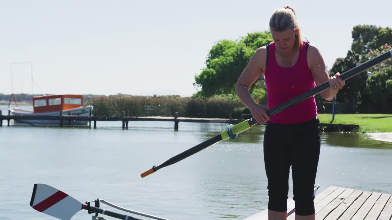 Senior caucasian woman preparing rowing boat in a river