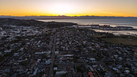 Fast-aerial-tracking-timelapse-over-Nelson,-New-Zealand-at-sunset,-just-before-dark