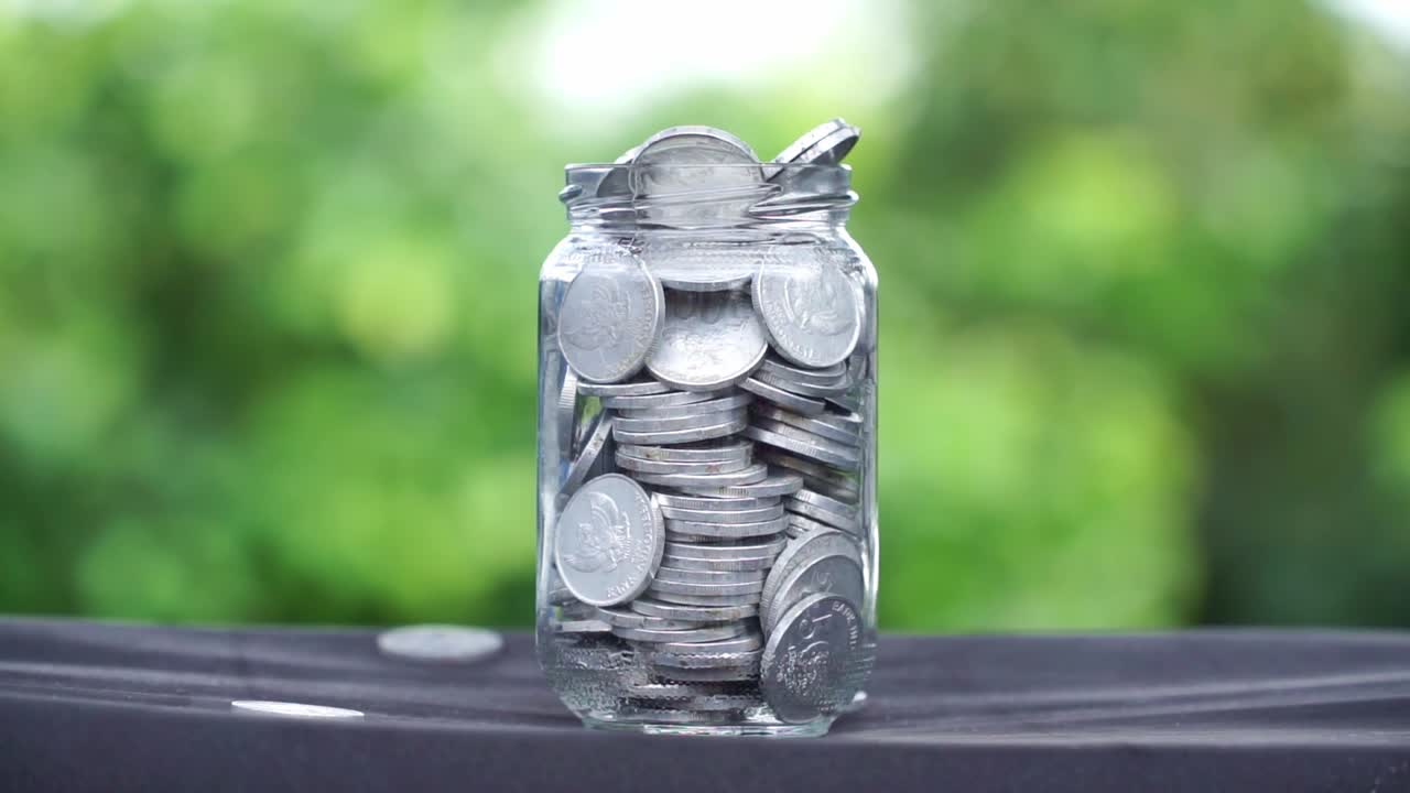 お金でいっぱいのガラス瓶のクローズアップショット