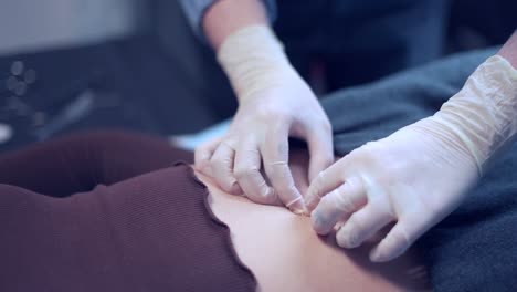 crop piercer inserting piercing into belly button