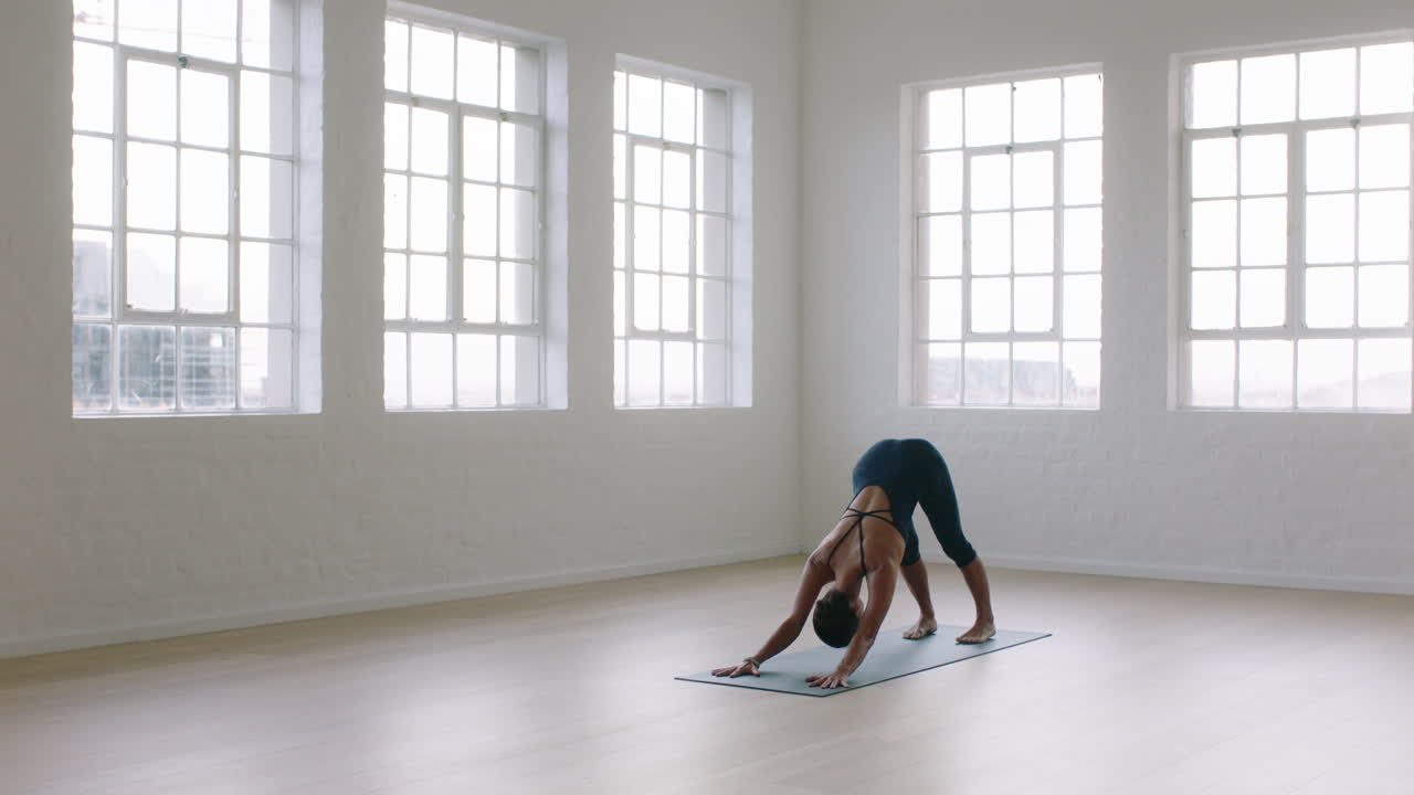 schöne yoga-frau praktiziert die pose eines nach unten gerichteten hundes und genießt den fitness-lebensstil, trainiert im studio und dehnt den flexiblen körper, trainiert frühmorgendliche meditation auf einer trainingsmatte