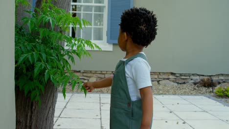 Side-view-of-cute-little-black-baby-playing-in-back-yard-of-their-home-4k