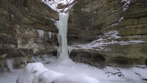 frozen waterfall on majestic cliff during winter season snowfall
