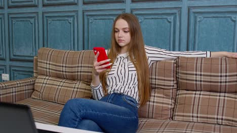 happy relaxed young woman holding smart phone looking at cellphone screen enjoying using mobile apps