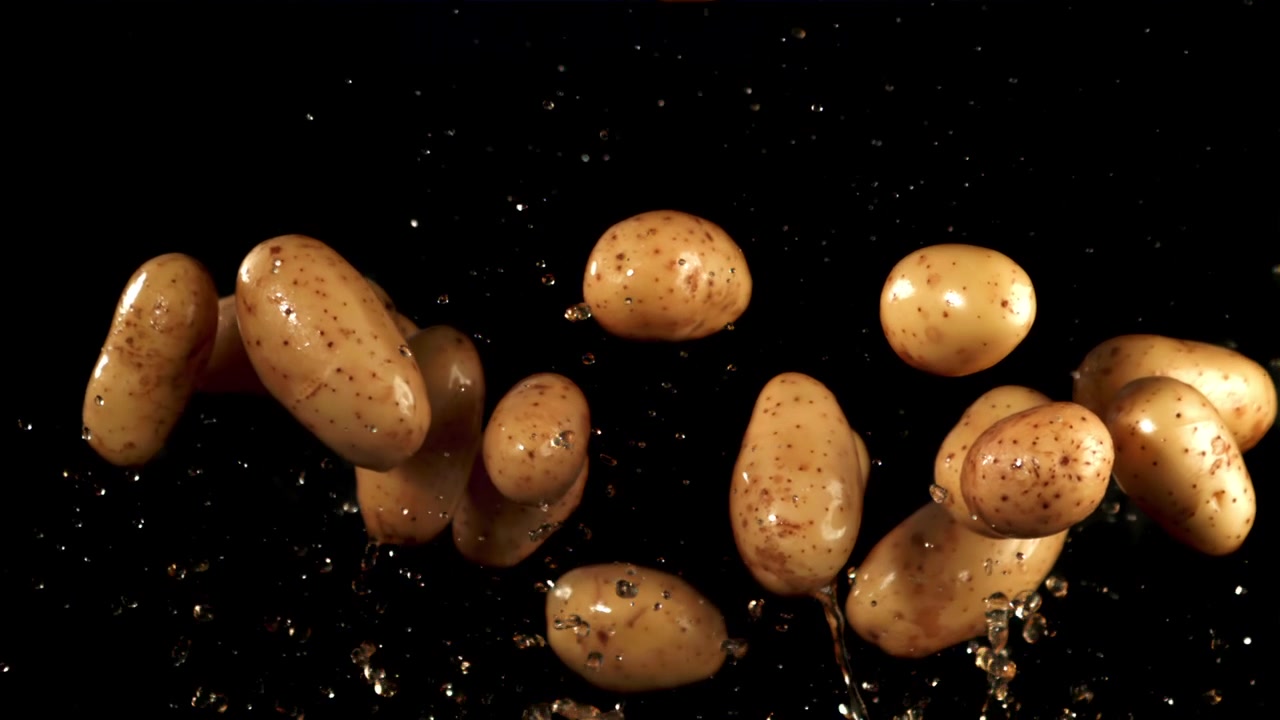 Patate fresche con goccioline d'acqua che cadono al rallentatore
