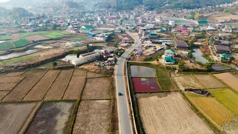 Toma-Aérea-De-Un-Coche-Entrando-En-Una-Ciudad-Rural.