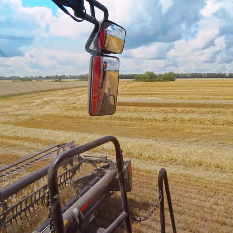 close-up combine working in summer. detail of grain harvester collecting ripe wheat on the field. part of agricultural machine in a bright day.