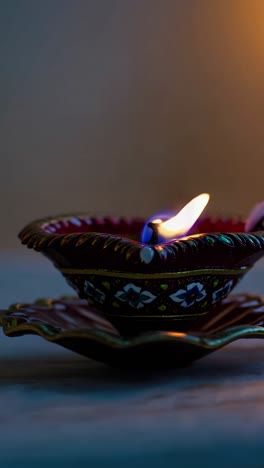 close-up, angled shot of a lit decorative oil lamp with intricate patterns, perfect for a serene