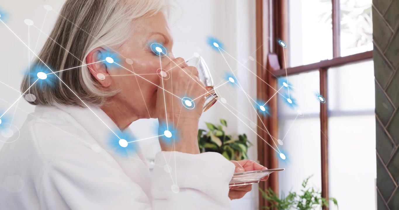 Senior woman reaching for cup by bathroom vanity sipping water scanning face overlay for health