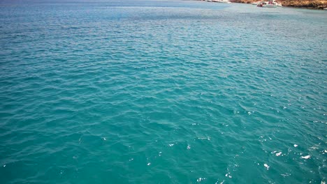handheld move beautiful ocean shot with rocks and boats in ayia napa cyprus filmed from boat