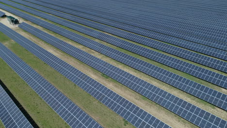 Low-Drone-Shot-Flying-Over-Rows-of-Solar-Panels-in-Solar-Panel-Farm-on-Sunny-Bright-Day