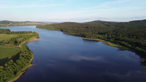 Ein-Blick-Auf-Einen-Breiten-Fluss,-Der-Zwischen-Wäldern-Und-Wiesen-Fließt