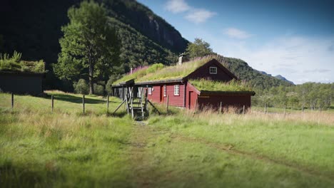 a traditional sod-roof houses stand in the wide valley at the mountain toothills