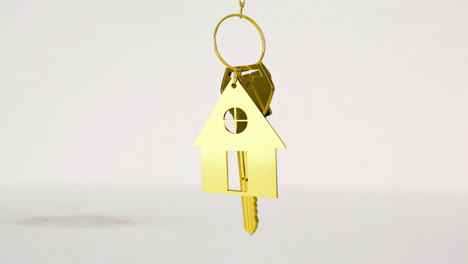 house keys and key fob hanging over 3d house model in the background