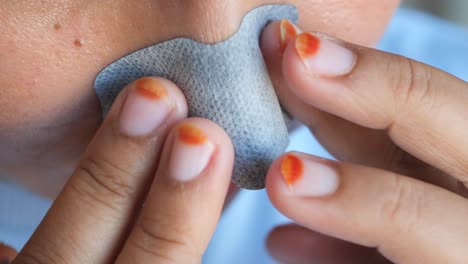 applying a nose patch for blackhead removal