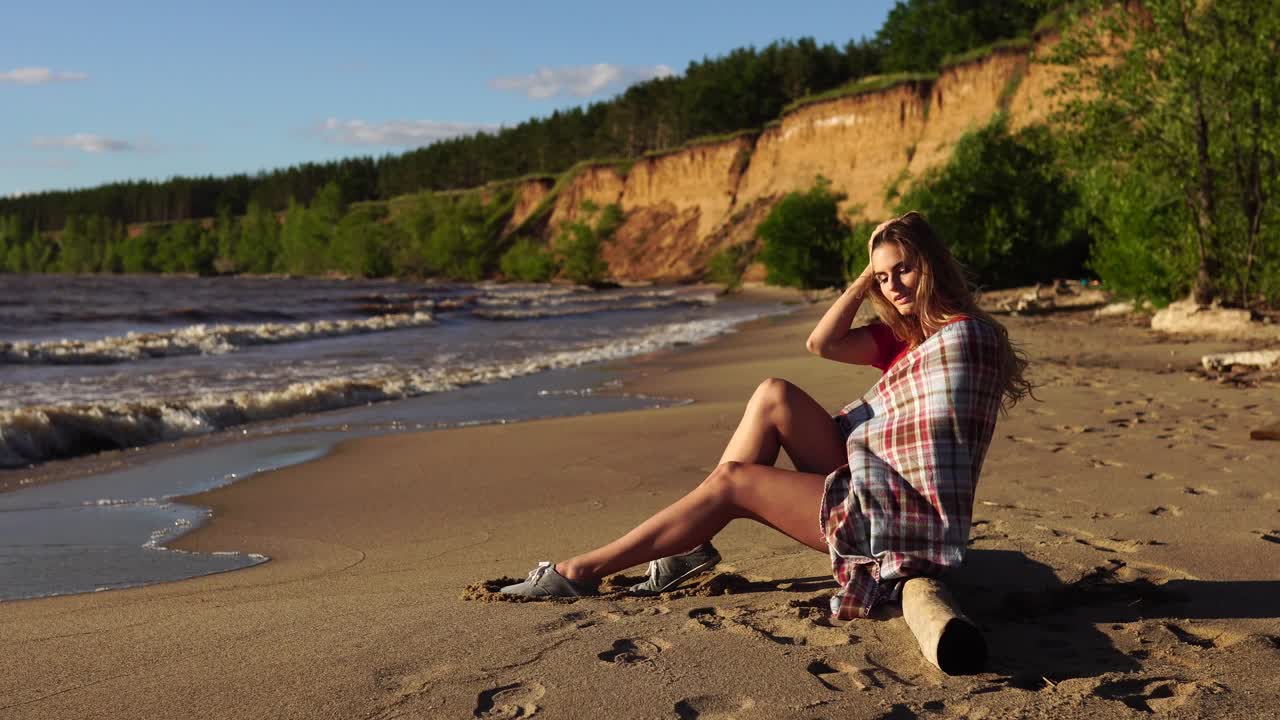 женщина отдыхает на пляже при заходе солнца