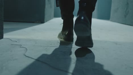 closeup of male legs in black boots. rear back view of man walking inside dark maze. man walking inside dark room, corridor. footage of mystical video. shot on arri alexa cinema camera in slow motion