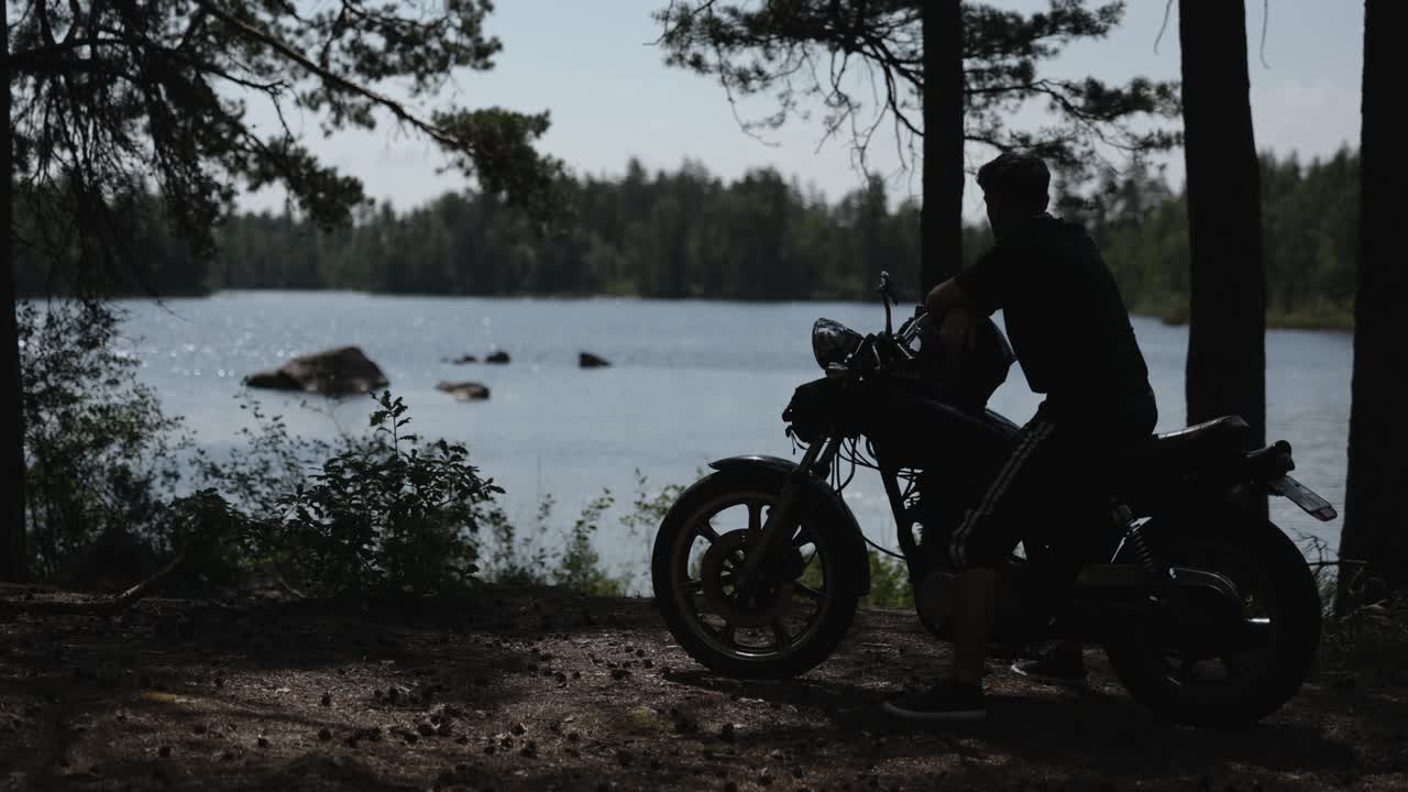 Man on motorcycle enjoying lake view