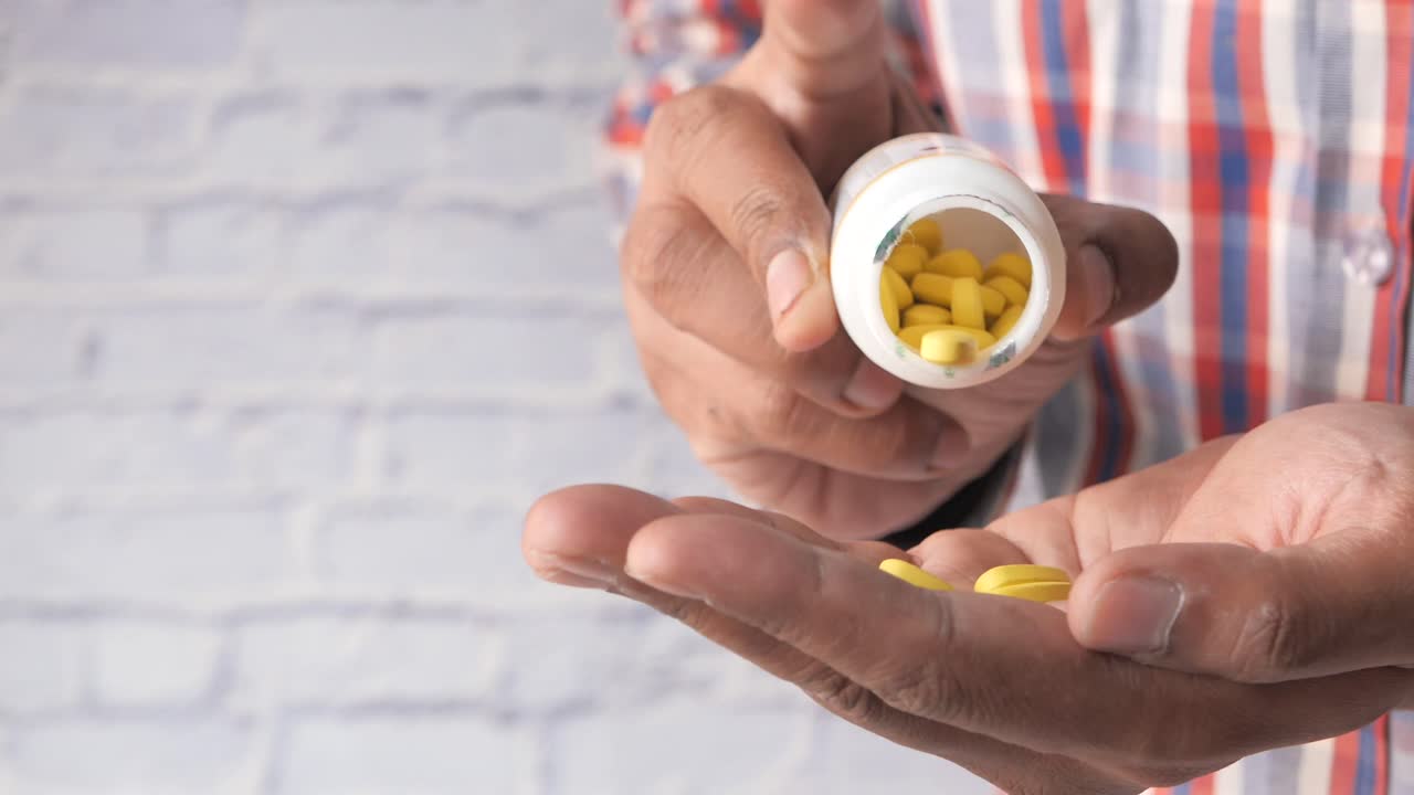 Man Taking Yellow Pills