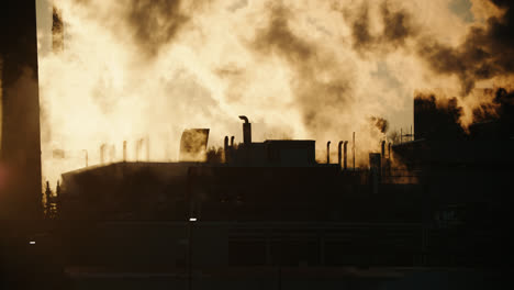 fábrica que emite una espesa contaminación por emisiones de humo tóxico durante la puesta de sol