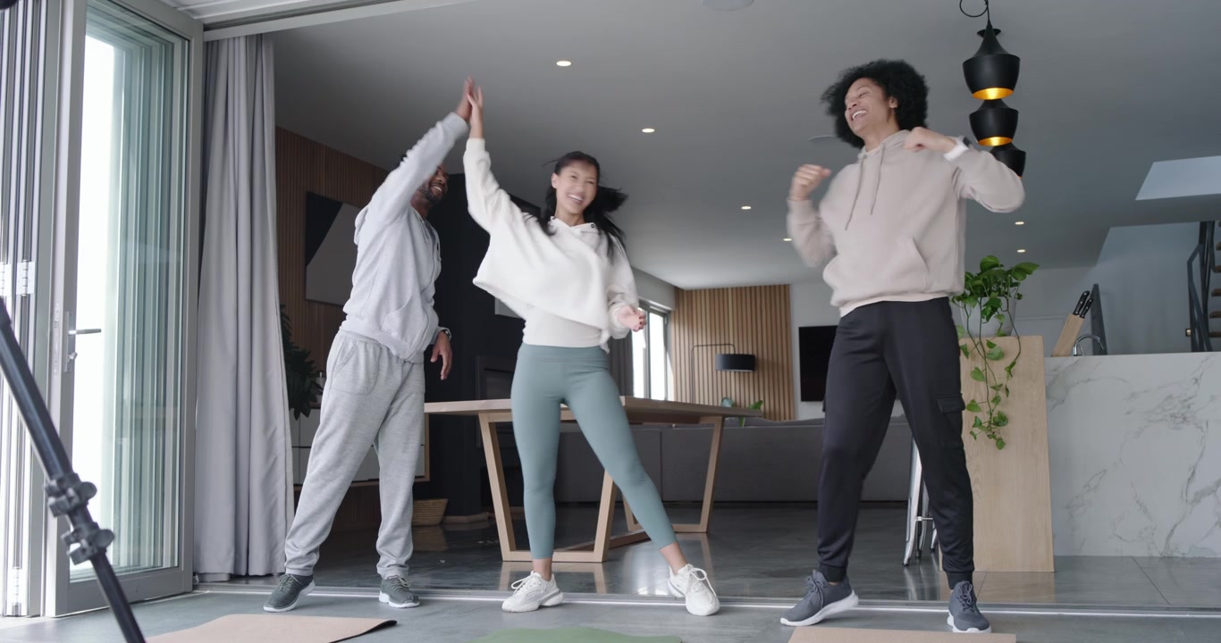 Amici africani che iniziano il riscaldamento alzando le braccia e facendo stretching su tappetini da esercizio vicino a porte a vetri.