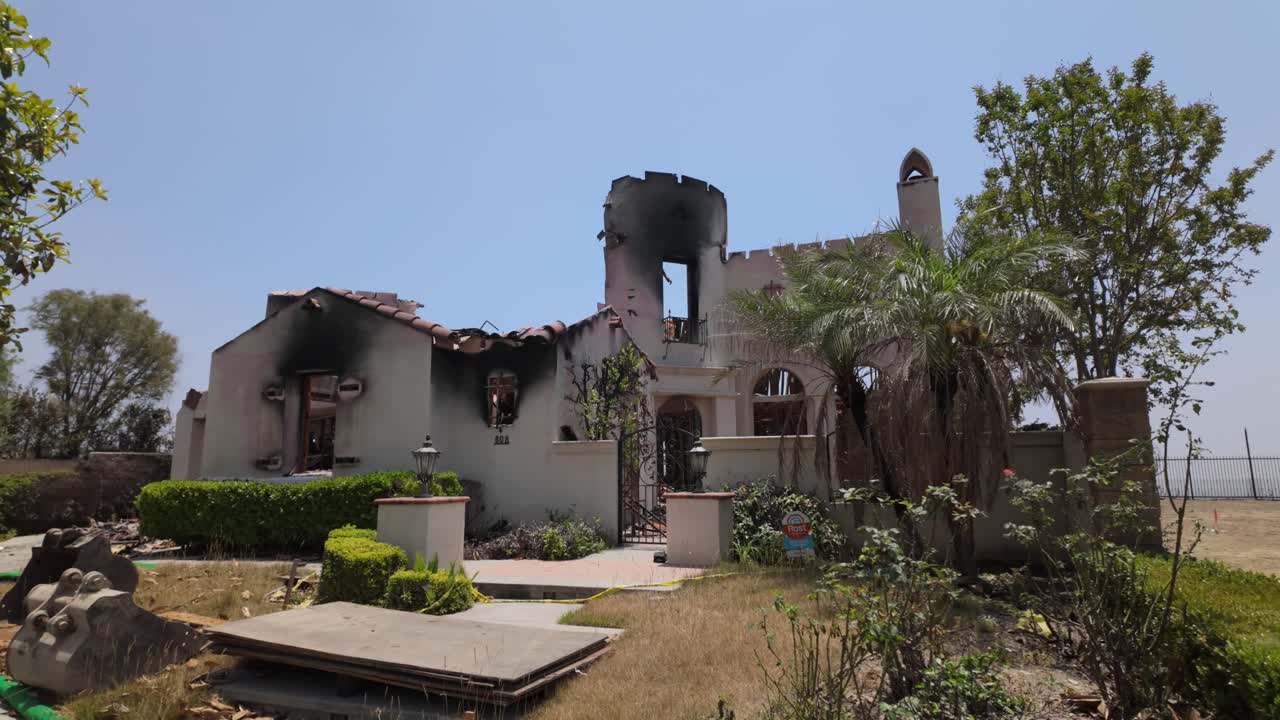 Gimbal panning shot revealing the charred ruins of a home burned by the wildfire in Altadena, California. 4K