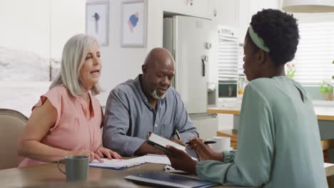 happy senior diverse couple with african american female friend talking about work