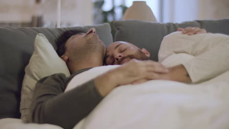 homosexual men hugging while sleeping in bed in morning