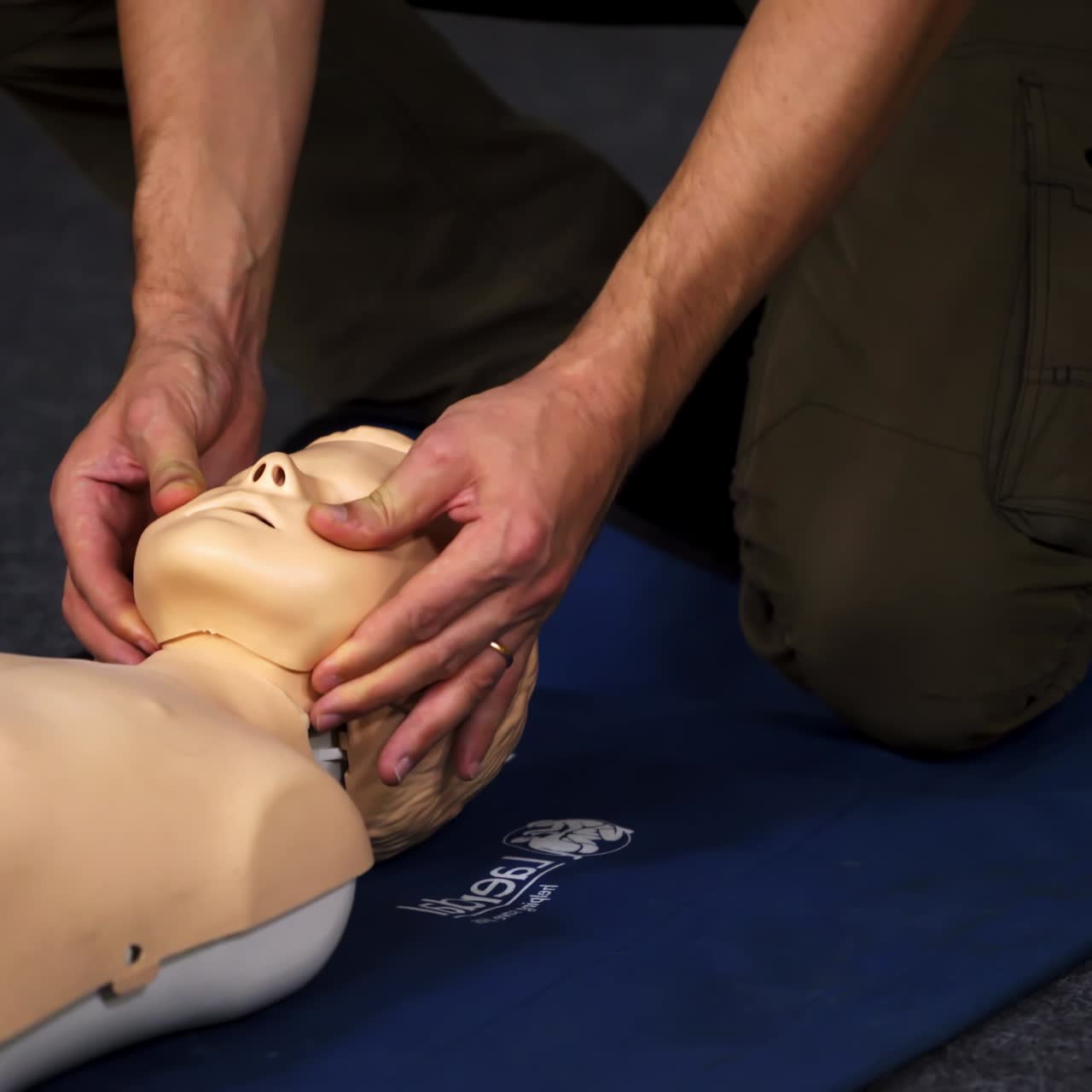 Experienced doctor shows methods of health treatment on medical dummy. Selective focus from the side