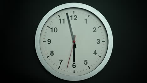 o relógio de parede branco mostra a hora 2 minutos para as 6 horas.