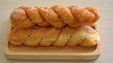 Donut de azúcar en forma de espiral sobre placa de madera