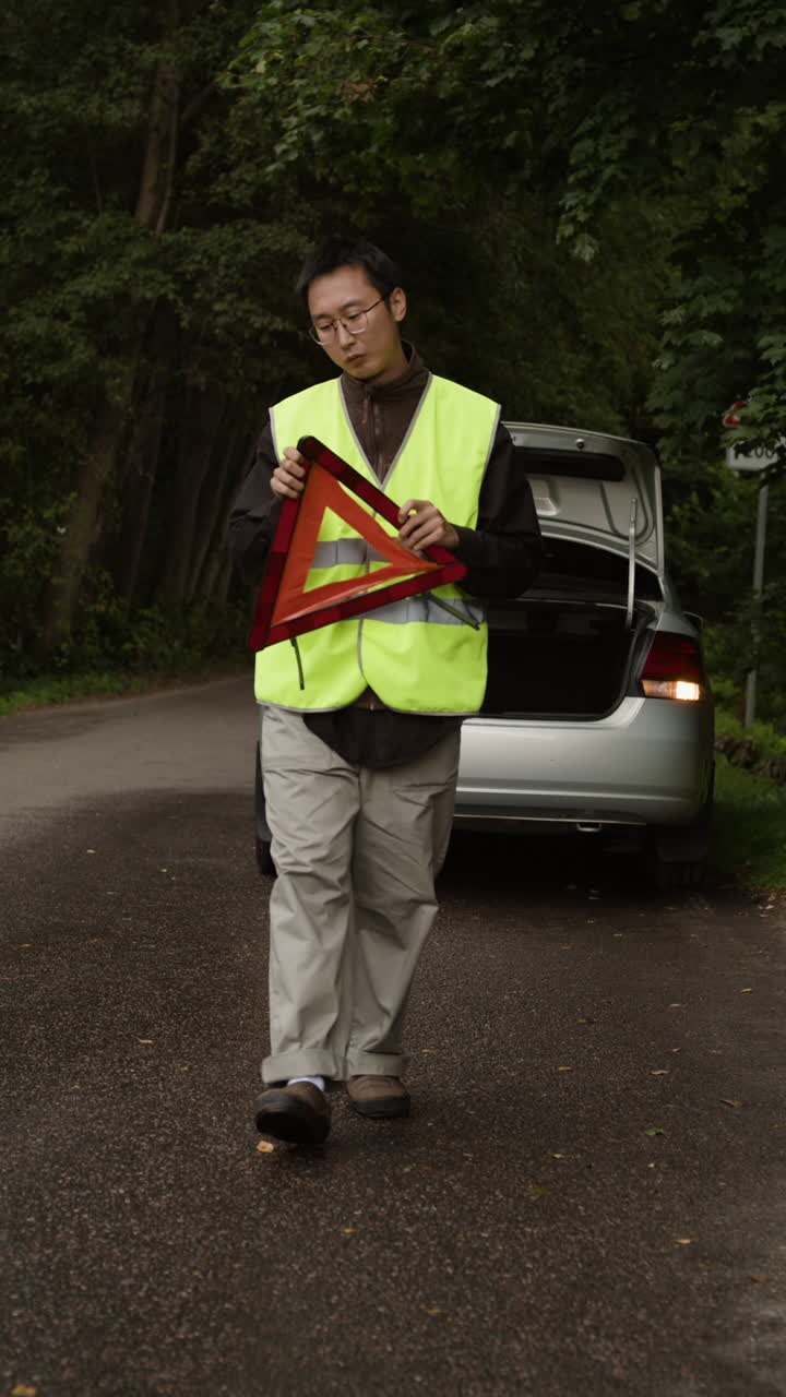 Uomo con triangolo di emergenza e auto